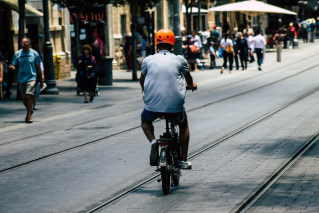 רוכב אופניים על פסי הרכבת במרכז העיר