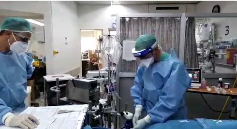 ד״ר מארק רומיין, רופא בכיר ביחידה לטיפול נמרץ קורונה בהדסה, עם מכשיר האקמו בפעולה